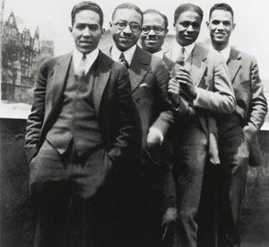 Pictured here are Langston Hughes [far left] with [left to right:] Charles S. Johnson, E. Franklin Frazier, Rudolph Fisher and Hubert T. Delaney, on a Harlem rooftop on the occasion of a party in Hughes' honor, 1924.
